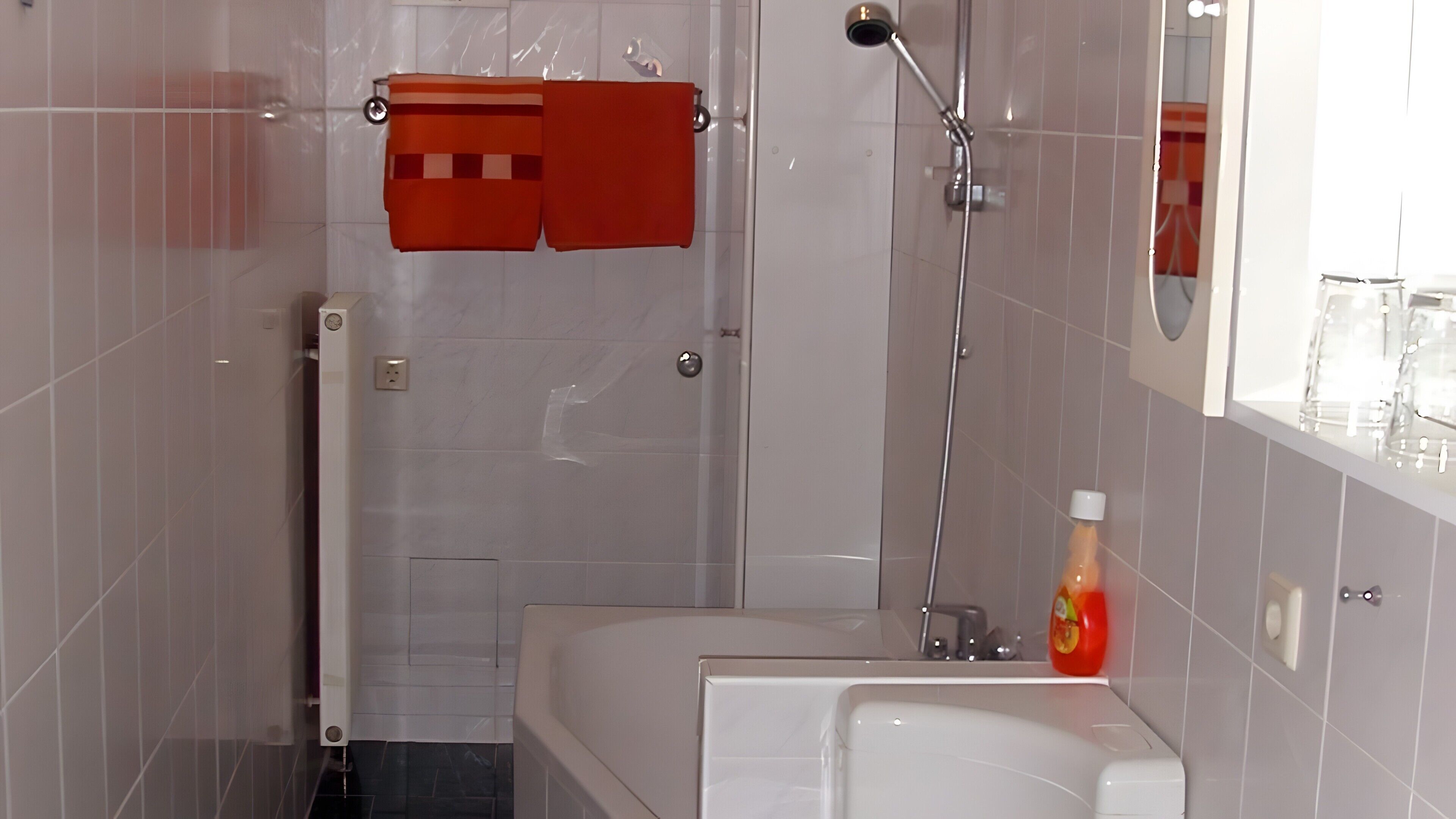 A modern bathroom with a shower, a bathtub, and a toilet.