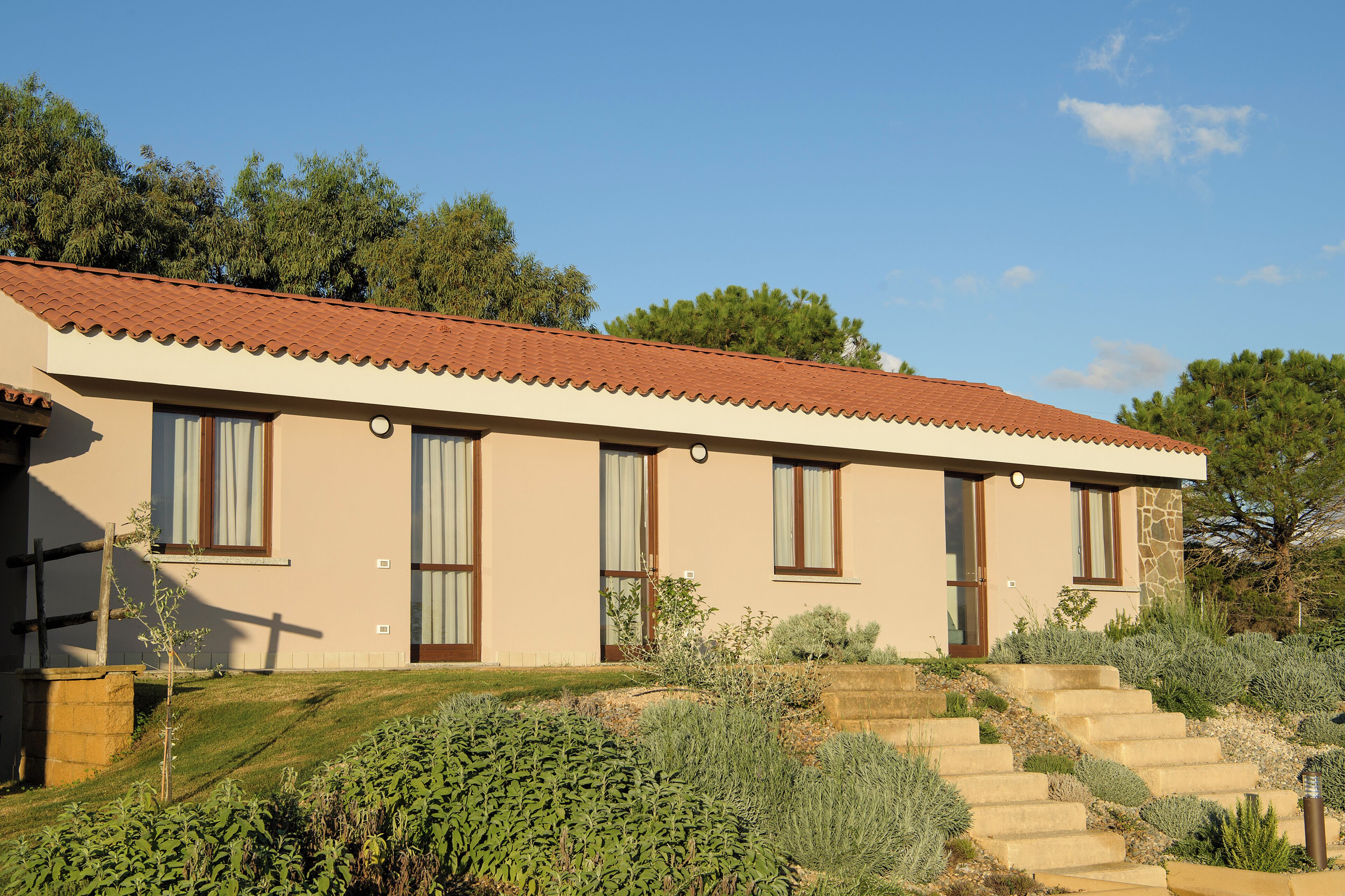A two-story building with a tiled roof, large windows, and a stone facade.