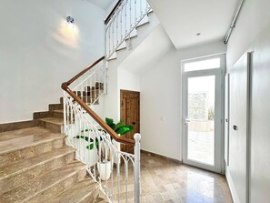 A staircase with white railings and wooden steps leading to a landing. - Appartement Yasmina 1 Bedroom (Sidi Bou Said)