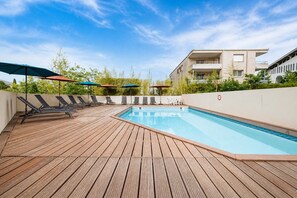 A rooftop pool with wooden decking, lounge chairs, and umbrellas. - Bright apartment for 4 people, with a garden (Grasse)
