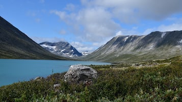 Eine Berglandschaft mit einem See, felsigem Gelände und vereinzelter Vegetation.