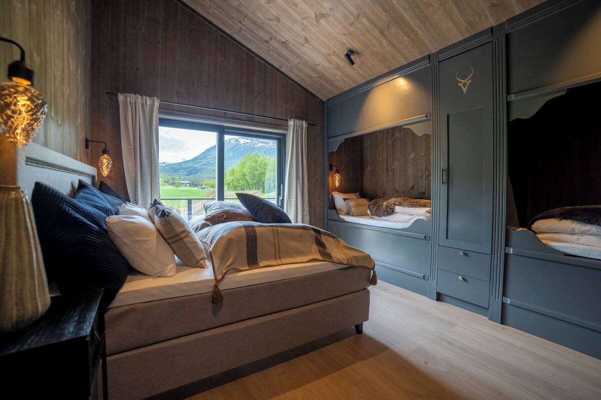 Ein Schlafzimmer mit einem Bett, einem Fenster mit Bergblick und einem Kleiderschrank.