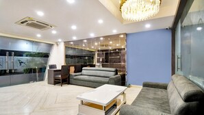 A modern living room with a sofa, a coffee table, and a chandelier.