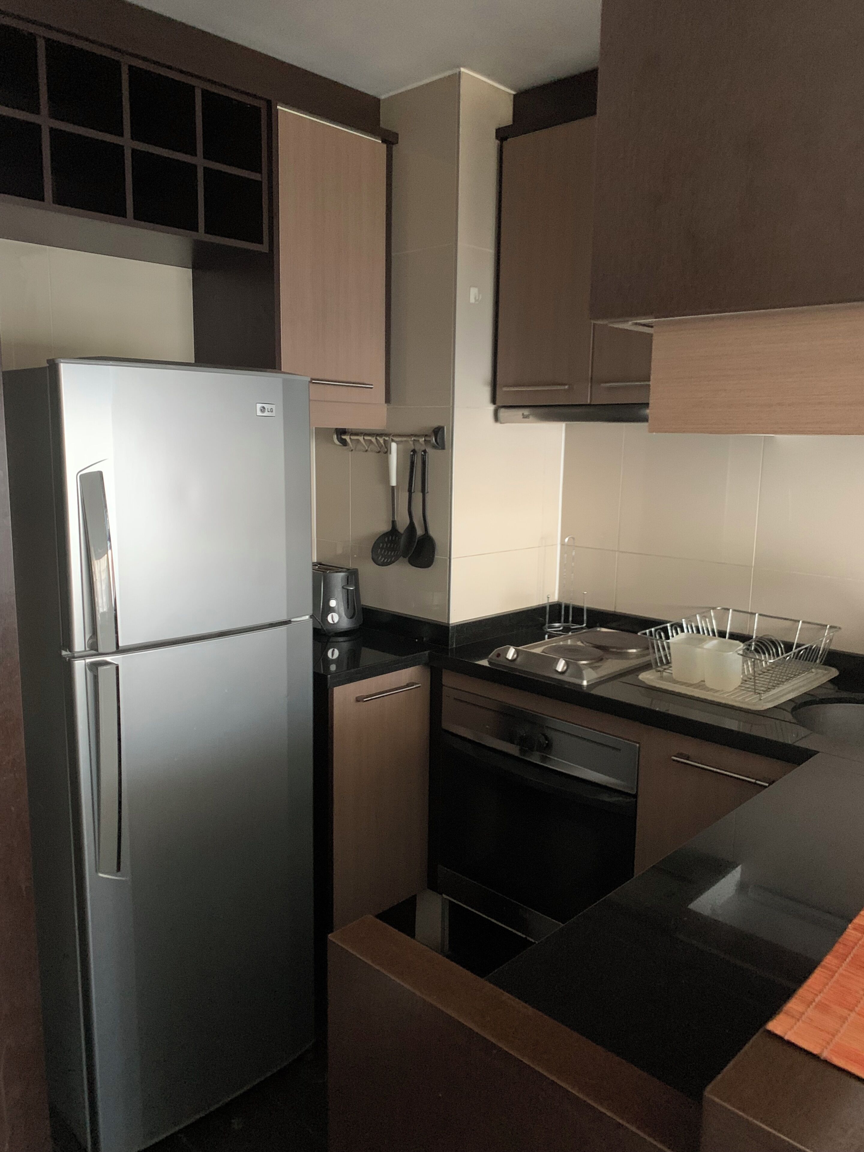 Een moderne keuken met roestvrijstalen apparatuur, houten kastjes en een zwart aanrecht.