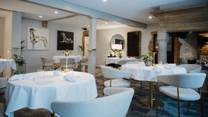 A restaurant with round tables, white tablecloths, and grey chairs. - Les Vieux toits (Hauterive)