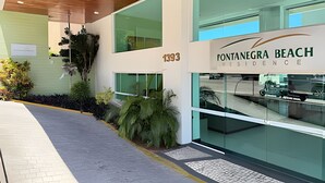 Un edificio moderno con un letrero que dice 'Fontanegra Beach Residence'.