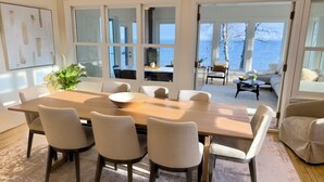 A dining area with a large table and chairs, a potted plant, and a view of the outdoors. - The Jenswold House on Lake Superior with Panoramic Views and Lake Access (Duluth)