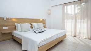 Ein Schlafzimmer mit einem hölzernen Kopfende, einer weißen Bettdecke und einem Nachttisch mit einer Lampe.
