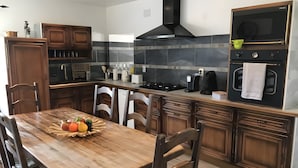 A modern kitchen with wooden cabinets, a central island, and a built-in oven.