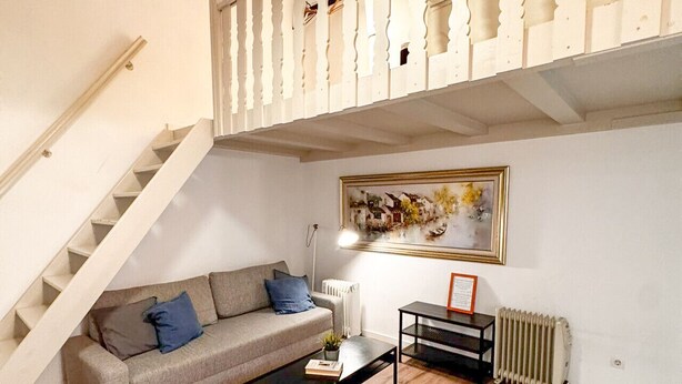 Ein Wohnzimmer mit einer Couch, einem Couchtisch und einem Bild an der Wand.