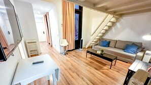 Ein Wohnzimmer mit einer Couch, einem Couchtisch und einer Treppe zu einer weiteren Ebene.