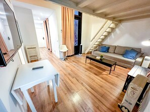 Ein Wohnzimmer mit einer Couch, einem Couchtisch und einer Treppe zu einer weiteren Ebene.