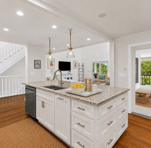 A modern kitchen with white cabinetry, granite countertops, and stainless steel appliances. - 806 Carolina - 1 Block to Beach/Ocean! (Isle of Palms)