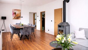 A modern living room with a dining area, a fireplace, and a sofa. - Vacation home in secluded location near Eifel National Park (Mechernich)