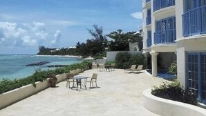 Ein Hotel mit Poolbereich, Sitzgelegenheiten im Freien und Meerblick.