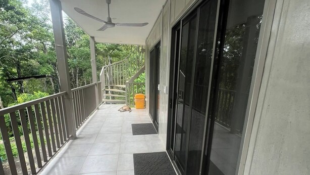 A covered balcony with a ceiling fan, a tiled floor, and a view of trees. - Montezuma Jungle Room with Shared Bath, A/C and fast WiFi (Montezuma)
