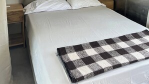 A bedroom with a bed, a window, a red curtain, a ceiling fan, and a nightstand. - Montezuma Jungle Room with Shared Bath, A/C and fast WiFi (Montezuma)