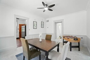 A dining room with a wooden table, chairs, a ceiling fan, and a foosball table. - 3BR, Quiet Street, 10 Min DTW (Cincinnati)