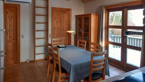 A dining area with a table, chairs, a cabinet, and a window with a view. - 4 Star Holiday Home in Sjolund (Sjølund)