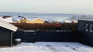 A residential area with houses, a view of the sea, and a snow-covered ground. - 4 Star Holiday Home in Sjolund (Sjølund)