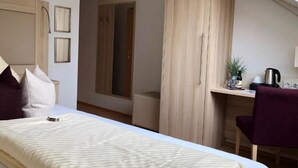 A bedroom with a bed, a desk, a chair, and a wardrobe. - Haus Mechthild (Sindelfingen)