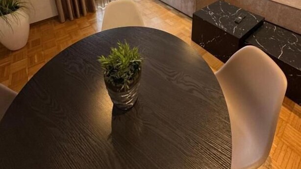 A modern living room with a sectional sofa, a round dining table with a potted plant, and a large window with curtains. - Haus Mechthild (Sindelfingen)
