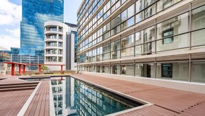 Un edificio moderno con zona de piscina, ventanas amplias y piscina reflectante.
