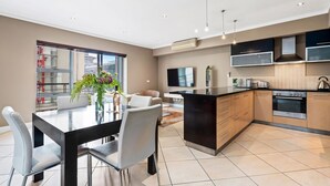 Una cocina moderna con comedor, ventanas amplias y un televisor de pantalla plana.