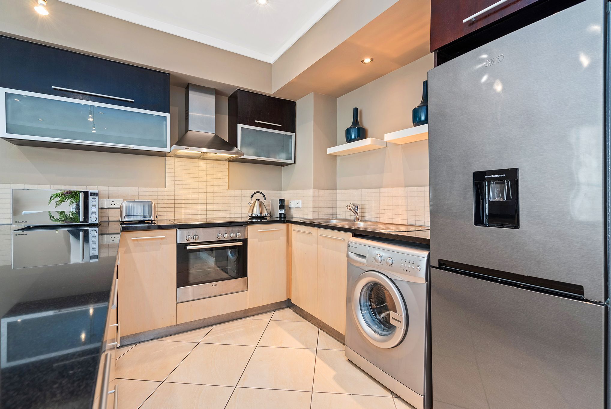 A modern kitchen with stainless steel appliances, a built-in oven, microwave, and dishwasher.