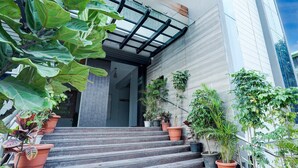 A staircase leading to a building entrance with potted plants on the steps. - Deluxe Onyx Hotel (Bengaluru)
