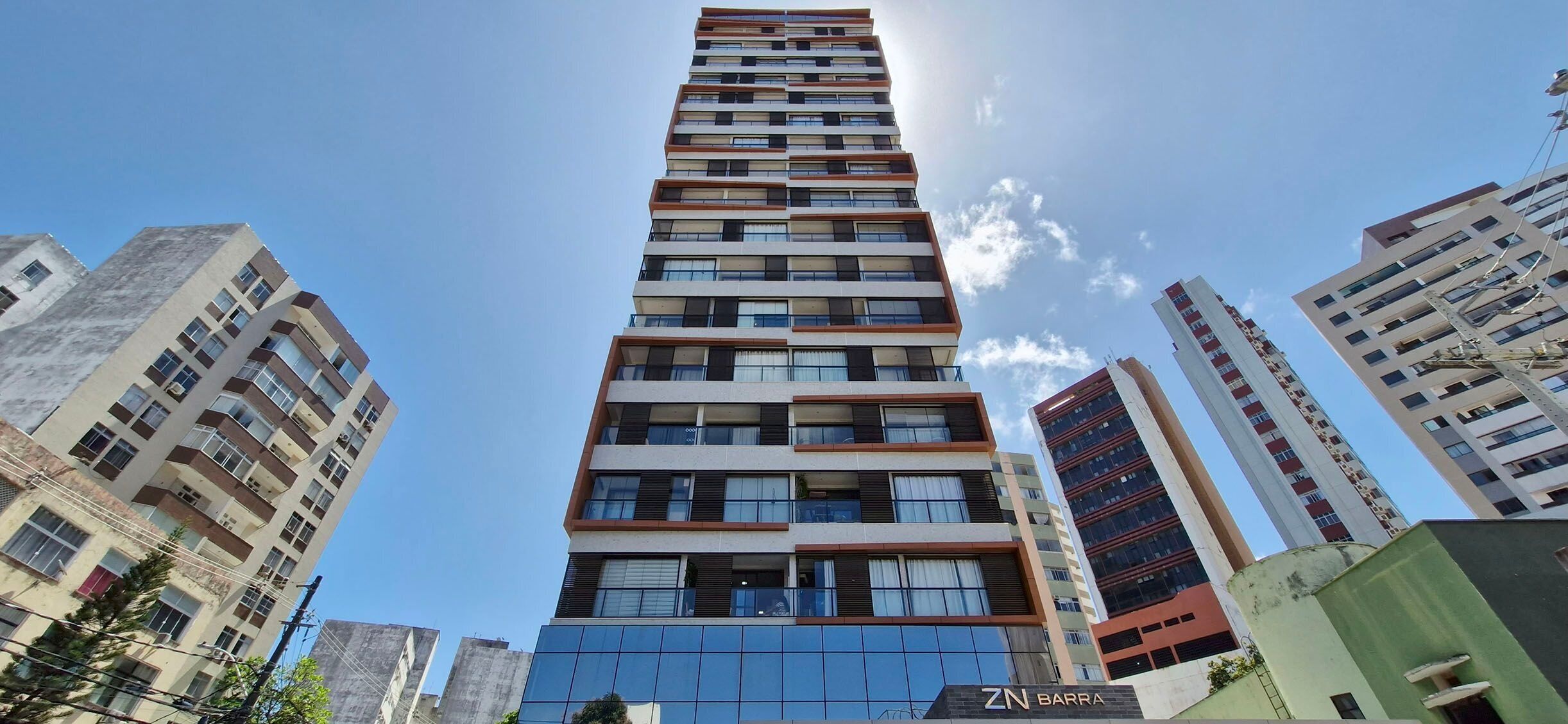 Un immeuble moderne de grande hauteur, doté de nombreux balcons, avec un ciel dégagé.
