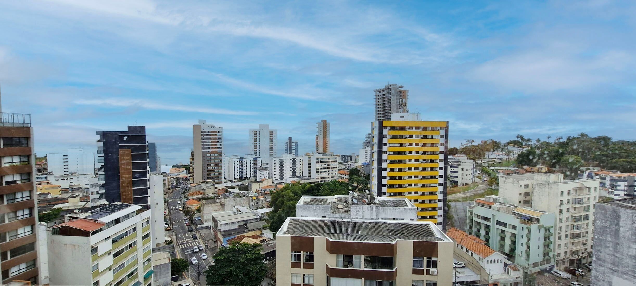 A cityscape with high-rise buildings, a mix of residential and commercial structures, and a clear sky.