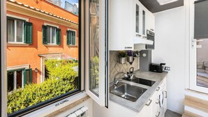 Eine kleine Küche mit Fenster, Spüle und Schränken.