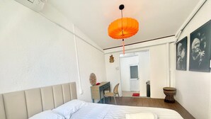 A bedroom with a bed, a desk, a chair, and a hanging lamp. - Cherry Blossom Boutique Hotel (Ho Chi Minh City)