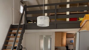 Una cocina moderna con comedor, una escalera y un altillo.