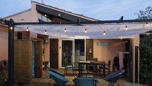 Un patio al aire libre cubierto con una mesa y sillas, luces colgantes y un letrero que dice 'SOUTH BEACH'.