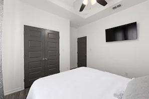 A bedroom with a bed, a ceiling fan, and a TV mounted on the wall. - The Spacious Nest 3BR/2BA,King Bed,Near Hospital (Edinburg)