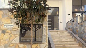A stone wall with a tree, a window, and a staircase. - GoldApartment  (Sarandë)