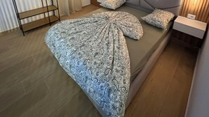 A bedroom with a bed, bedside tables, a wardrobe, and a headboard with a light fixture. - GoldApartment  (Sarandë)