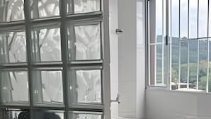 A kitchen with a large window, a white refrigerator, and a black countertop.