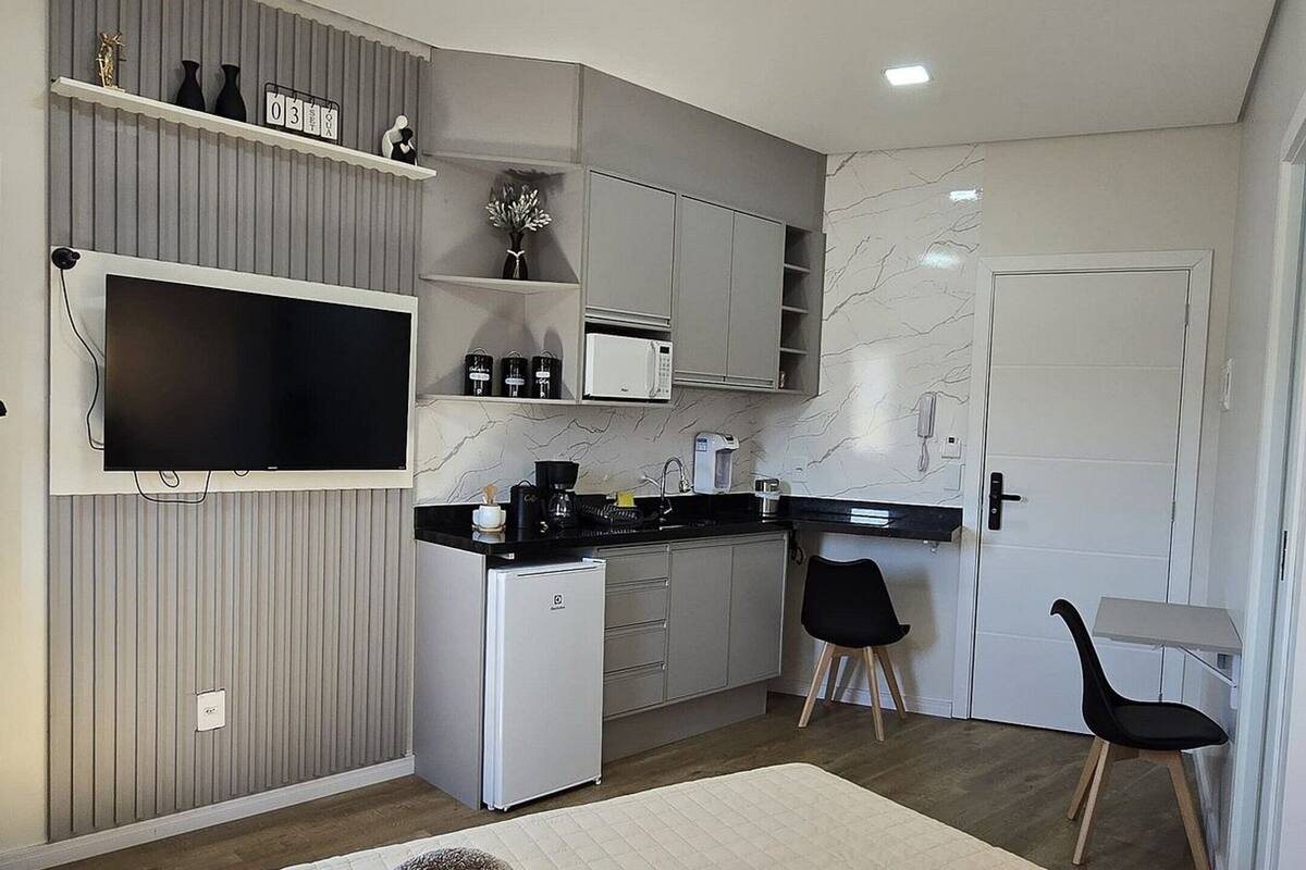 A compact bedroom with a bed, a bedside table, and a chair.