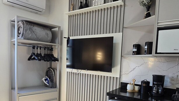 A modern kitchen with a built-in TV, a refrigerator, and a coffee machine. - Residencial Felicita (Barueri)
