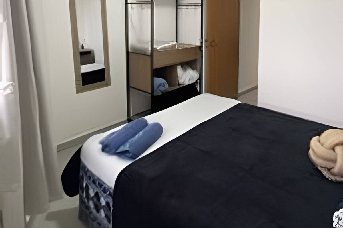 A bedroom with a bed, a wardrobe, a mirror, and a door.