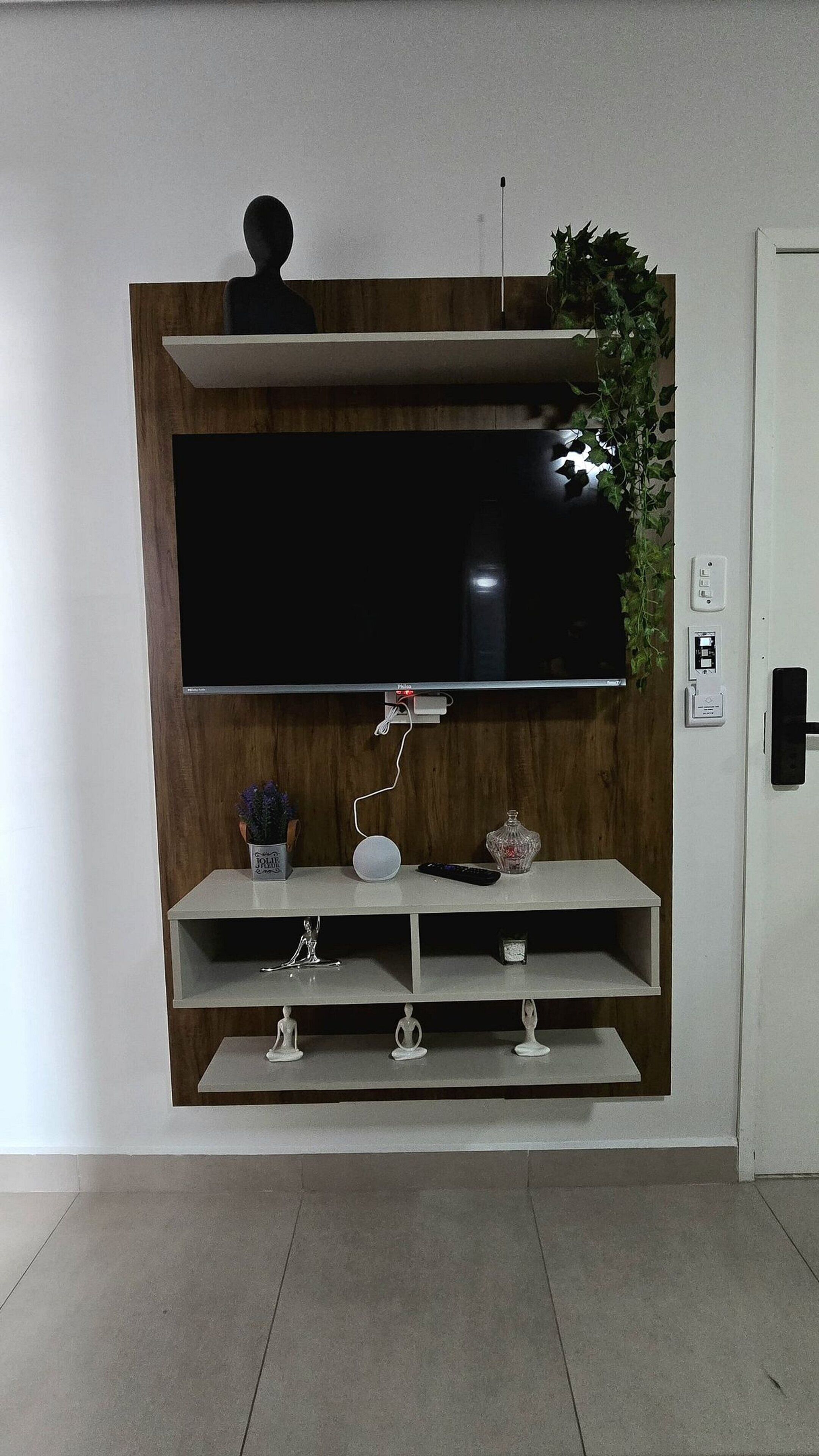 A modern living room with a large flat-screen TV mounted on a wooden wall unit.
