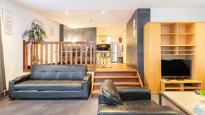 Una sala de estar moderna con un sofá, una mesa de centro y un mueble para televisor.