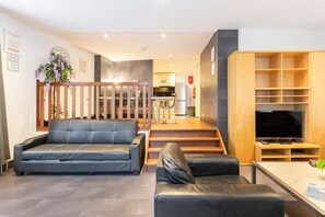 Ein modernes Wohnzimmer mit einer Couch, einem Couchtisch und einer TV-Konsole.