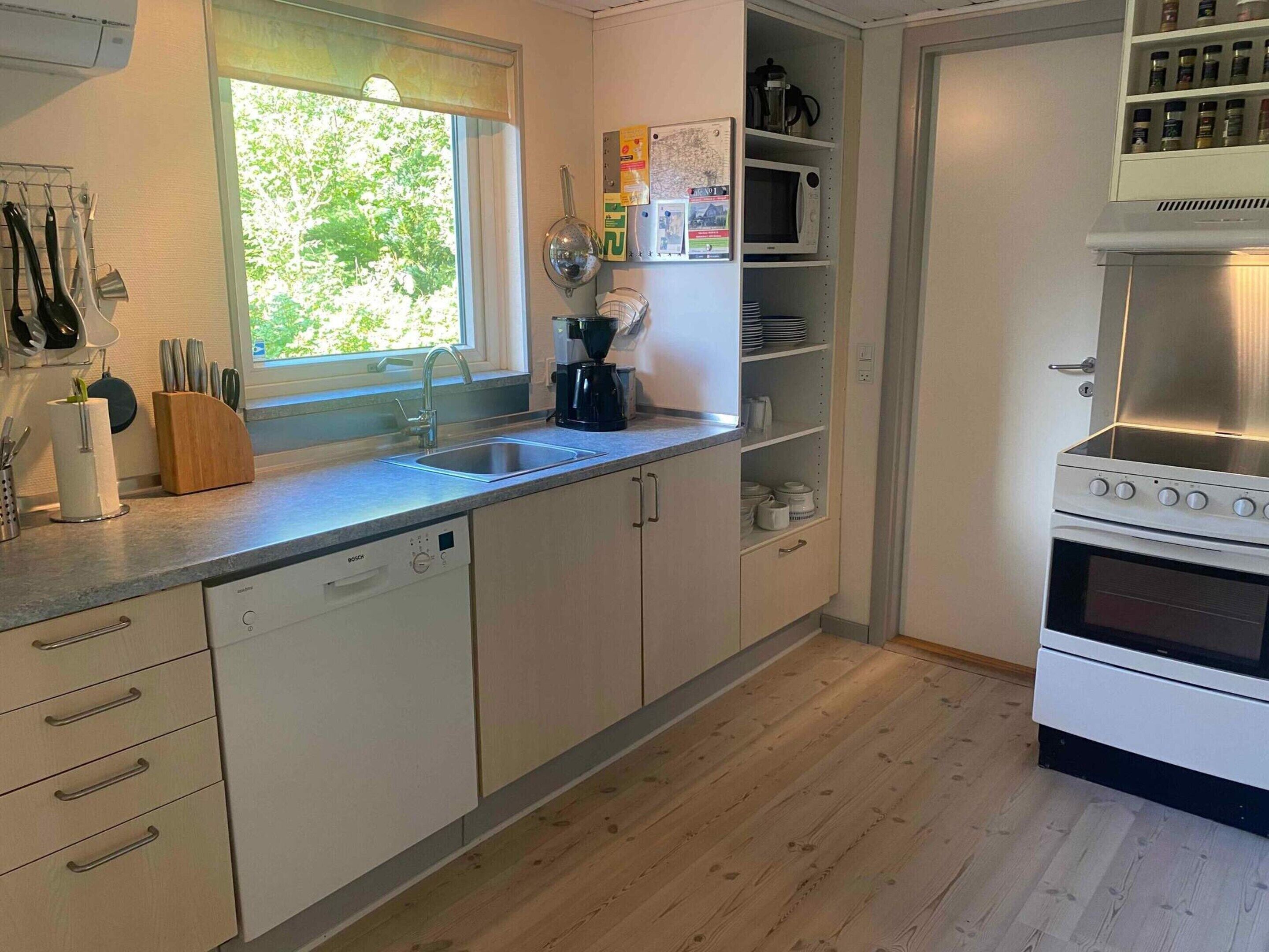 A modern kitchen with a Bosch dishwasher, a coffee maker, and a stove.
