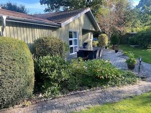 A house with a paved patio, a small garden, and a window. - 4 Star Holiday Home in Glesborg (Glesborg)