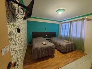 A room with two beds, a ceiling light, a window with curtains, and a wall with floral wallpaper. - Hostal Le Ciel Uyuni (Uyuni)