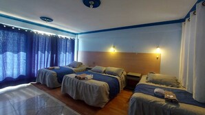 A hotel room with two beds, a wooden floor, a patterned rug, and a window with curtains. - Hostal Le Ciel Uyuni (Uyuni)